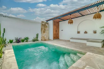 Poolside terrace with a built-in bench, loungers, stone paving and a timber pergola.