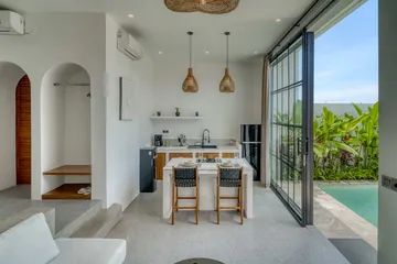 Open-plan dining and kitchen area with arched wall niches and courtyard glazing.