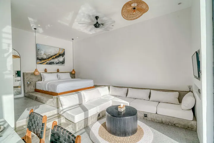 A light-filled living or kitchen space with pale finishes and timber furniture.