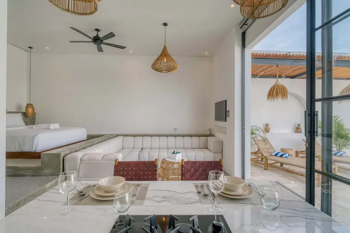 Dining setting in the foreground with glass wall looking into the bedroom and lounge.