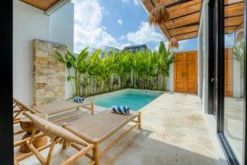 Courtyard seating and pool beside the villa's glass frontage.