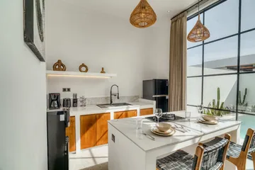 Kitchen island set with place settings beside the sink counter and full-height glazing.