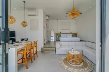 Kitchen counter with stools in front of the sectional sofa and bed.