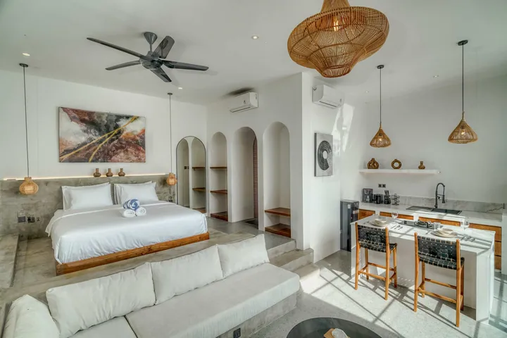 A light-filled living or kitchen space with pale finishes and timber furniture.