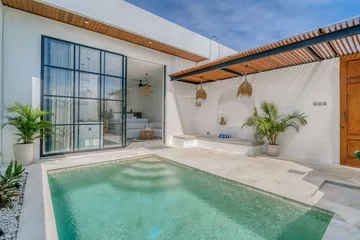 Pool terrace beneath a timber canopy beside a glass-fronted white room.
