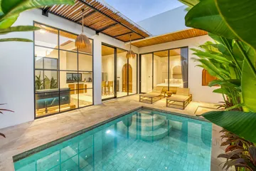 The courtyard pool at dusk, with warm light inside the surrounding rooms.