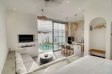 Sectional sofa, television and dining island beside full-height glass doors to the courtyard.