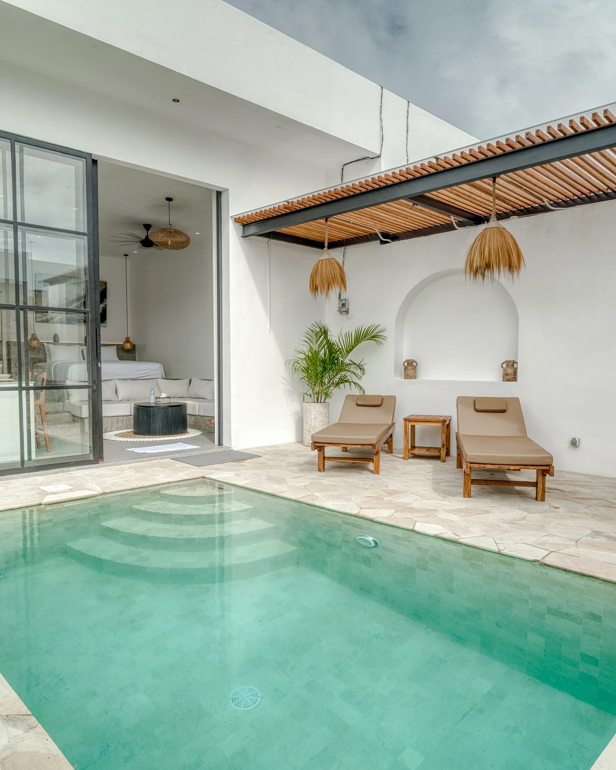 Avasa A7 courtyard pool, with glass bedroom doors, timber shade, two loungers and cactus planting.